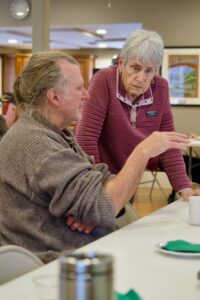 Two supporters confer after Tom O'Donnell's remarks at the Bentonsport Stone House.